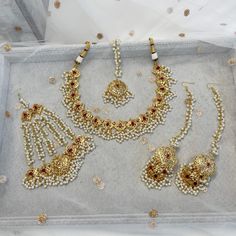 Luxury gold plated bridal set made with ruby gems, Finished with an abundance on tiny pearl bead detailing.  Set comes complete as seen with necklace, jhumar, earrings with attached hair chains and tikka.  This set is ready to ship as seen with gift box. Full Bridal Jewellery Set, Indian Wedding Jewelry Sets, Hair Chains, Fancy Jewellery Designs, Bridal Necklace Set, Small Necklace, Indian Wedding Jewelry, Fancy Jewellery, Fancy Jewelry