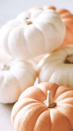 pumpkins and gourds sitting on a table