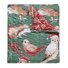 a green quilted blanket with birds and berries on it