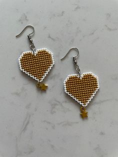 two heart shaped earrings with gold stars on them