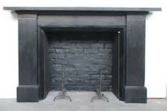 a black fireplace with two iron legs