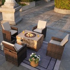 an outdoor fire pit surrounded by wicker furniture