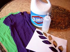 a bottle of cleaner sitting on top of a table next to clothes