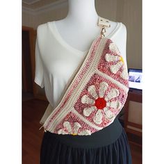 a crocheted purse on a mannequin's torso with a white shirt in the background