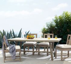 an outdoor table with chairs and fruit on it