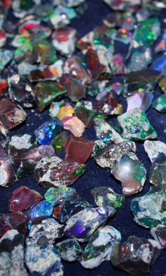 many small pieces of glass sitting on top of a blue surface with white and green flecks