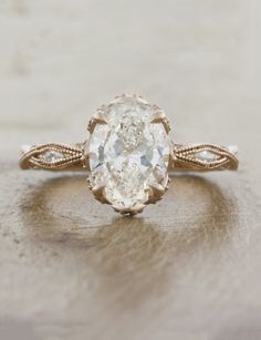 an oval shaped diamond ring on a table