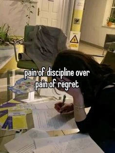 a woman sitting at a table with papers and pen in her hand, writing on the paper