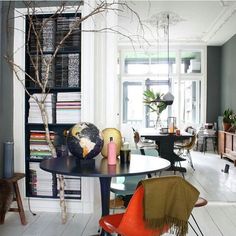 a living room filled with lots of furniture and bookshelves next to a window