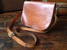 "Vintage Brown Leather Messenger Saddle Bag Handcrafted Vintage Heavy thick saddle leather, silver buckle closure with leather strap, adjustable shoulder strap. Color is a very lovely cinnamon brown with a rich heavy patina. White stitch detail. 2 interior compartments separated by a piece of leather. No lining. Measures; 9\" length, 7\" height, approx. 3.5\" depth, strap drop is 21\" at longest length and is adjustable. Wonderfully aged to perfection, this bag has an awesome patina only years o Cognac Saddle Bag With Leather Lining, Classic Leather Strap Crossbody Saddle Bag, Brown Leather-lined Saddle Bag, Classic Brown Saddle Bag, Leather Handle Saddle Bag, Brown Leather-backed Saddle Bag, Crossbody Saddle Bag, Cinnamon Brown, Aged To Perfection