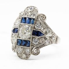 The Bella ring is an authentic vintage diamond ring from the Art Deco Era circa 1920. It centers 1 old mine cut diamond of I color and SI3 clarity that weighs 1.05ctw. Sixteen old mine cut diamonds of H color and VS2 clarity that weigh 0.90ctw and 10 natural calibrated French cut sapphires that weigh 1ctw are set throughout the setting of this ring. This ring is size 7 ½ and can be sized. Ring measurement: 22mm by 18mm by 5mm Total weight: 6.8 grams/ 4.4dwt Luxury Antique Sapphire Ring With Rose Cut Diamonds, Luxury Art Deco Rose Cut Diamond Jewelry, Art Deco Jewelry Rings, Doing The Right Thing, Vintage Diamond Ring, Old Mine Cut Diamond, French Cut, Vintage Diamond Rings, Art Deco Glass