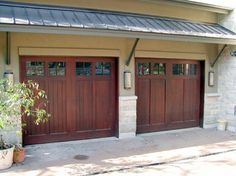 two brown garage doors in front of a house