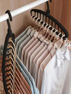 a rack with clothes hanging on it and a person's hand reaching for the hanger