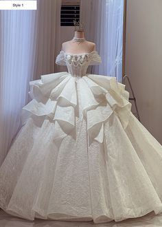 a white wedding dress on display in front of a mirror