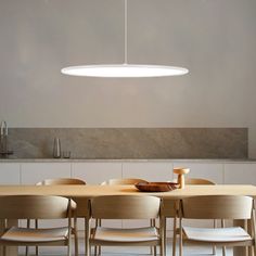 a dining room table with chairs and a bowl on the table in front of it