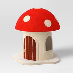 a red mushroom house with white dots on it's roof is shown in front of a gray background