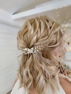 a woman with blonde hair wearing a bridal comb in her left half - up hairstyle