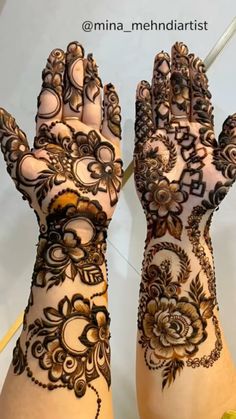 two hands with henna designs on them