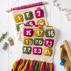 a crocheted wall hanging with numbers on it next to some crafting supplies