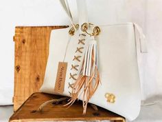 40x28x5 cm Handbag in engraved white cowhide leather. Two inner pockets, one of them with zipper. Zipper closure. Adornment in leather fringes and goose feathers. Braided ornament in leather lace. It is a handbag, but thanks to the size of the handles it is also designed so that you can look it on your shoulder when you want. The inner lining is premium fabric, sturdy, with reinforced seams. We work on very different and different colors and skin and fabric types. You can order this personalized White Tassel Shoulder Bag For Travel, White Travel Bags With Tassels, White Tassel Travel Bags, White Tassel Bags For Everyday Use, White Shoulder Bag With Tassels For Daily Use, White Everyday Bags With Tassels, White Tassels Bag For Everyday Use, White Tassel Shoulder Bag For Daily Use, White Fringe Travel Bag