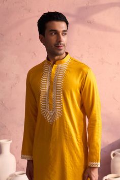 SHRESTHA BY VASTRAMAY Men's Yellow Silk Machine Embroidered Kurta Luxuriate in this vibrant yellow kurta, featuring intricate machine embroidery. Made from a silk blend, this kurta boasts a comfortable and stylish fit. Pair it with a dhoti or pajamas for a complete traditional look. Key Features Yellow silk blend with machine embroidery Mandarin collar Long sleeves Side slits Pockets Specifications Sleeve Length: Full Sleeves Top Shape: Straight Top Hemline: Straight Top Length: Knee Length Mate Festive Yellow Kurta With Intricate Embroidery, Yellow Embroidered Kurta For Diwali, Yellow Traditional Wear With Gold Embroidery For Festivals, Yellow Long Sleeve Traditional Wear With Intricate Embroidery, Traditional Designer Yellow Kurta, Yellow Kurta With Intricate Embroidery And Traditional Drape, Yellow Kurta With Intricate Embroidery For Festivals, Traditional Yellow Kurta With Intricate Embroidery, Yellow Kurta With Intricate Embroidery For Transitional Season