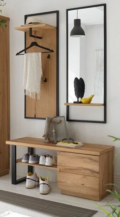 a wooden bench sitting under a mirror next to a wall mounted coat rack with shoes on it