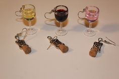 four wine glasses with corks in them sitting next to each other on a table