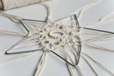 a close up of a star ornament on a table with some twine