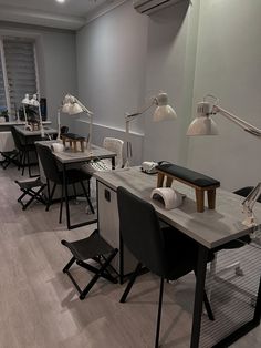 a row of desks with chairs and lamps on them