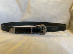 This is a 30mm wide black leather be (also available in Brown leather) with a three piece Weston style buckle set and a Zig Zag emboss on the edges, just add a note to seller with the waist size you would like, Waist size is from the buckle end of the leather to the middle hole then you will have three holes bigger and three holes smaller Black Leather Belt Buckles With Antique Buckle, Black Leather Belt Buckle With Antique Design, Formal Black Antique Belt Buckle, Classic Hand Tooled Leather Belt Buckles, Hand Tooled Silver Leather Belt Buckles, Classic Black Concho Belt Buckles, Leather Concho Belt Buckles For Formal Wear, Formal Leather Concho Belt, Custom Engraved Leather Belt Buckles