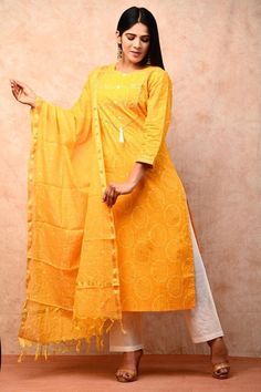 Add a touch of sartorial charm to your festival collection with this vibrant Yellow Kurti set. Crafted from a lightweight fabric, the Cotton Block Print top pairs perfectly with the white pant and Kota cotton dupatta. Not only does this ensemble look stylish, but it's also incredibly comfortable to wear. Elevate your festival style with this beautiful Kurti set. Size fits : XL Colour : Yellow Kurti/Pant Fabric : Cotton Length Of Kurti : 40 inches Sleeve length : 3/4 Sleeves Back Neck : High Neck Summer Chanderi Palazzo Set With Straight Kurta, Semi-stitched Cotton Sharara With Gota Work, Unstitched Cotton Palazzo Set With Zari Work, Designer Cotton Sets With Zari Work, Cotton Sharara For Diwali Designer Wear, Designer Cotton Sharara For Diwali, Designer Cotton Sharara With Straight Kurta, Cotton Palazzo Set For Designer Wear And Festivals, Cotton Sharara For Diwali