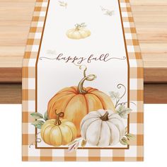 a table runner with pumpkins on it and the words happy fall written in cursive writing