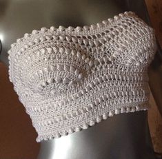 a close up of a mannequin's torso wearing a white crocheted crop top