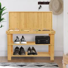 a wooden bench with shoes on it in front of a potted plant and suitcase