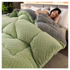 a woman laying on top of a bed covered in blankets and pillows next to a plant