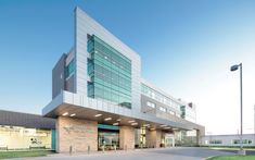 an empty parking lot in front of a large building with glass windows on the side