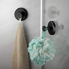 a shower curtain hook with a mesh ball hanging from it's side next to a towel rack