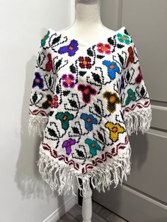 Beautiful Mexican Mañanitas in different colors and designs. Handmade by talented artisans in Mexico. This beautiful poncho will have your amigas complementing you! These are definitely a must-have for the holidays.These are all one-size. It fits Small, Medium and Large.Hermosas Mañanitas Mexicanas en diferentes colores y diseños. Hecho a mano por talentosos artesanos en México. Este hermoso poncho hará que tus amigas te complementen todas las veces! Definitivamente son imprescindibles para las Bohemian Handwoven Poncho For Festival, Handmade White Cotton Patterns, Folk Style Festival Poncho One Size, Multicolor Casual Shawl Poncho, Handmade Artisan Poncho For Festivals, Bohemian Handwoven Shawl Poncho, Handwoven Festival Poncho Shawl, Multicolor Long Sleeve Poncho For Beach, Bohemian Patterned Shawl