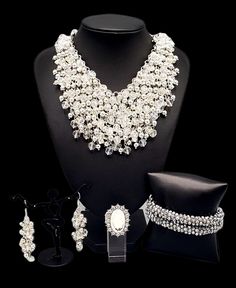 a necklace and earring set is displayed on a mannequin with other jewelry