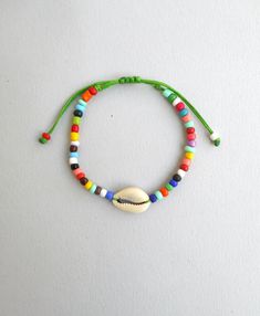 "Cowrie shell beaded bracelet, Colorful bracelet, Cowry seashell charm, Cowrie bracelet, Tribal bracelet, Surfer girl gift, Beach bracelet This beautiful cowrie shell and rainbow bead bracelet is a beachside staple look. It's perfect for any outfit and any mood. Choose between the string colors or order all of them! Wear them solo or together for a statement. It is made to order using genuine sea shells. Each shell is unique and hand chosen for its natural beauty. The waxed cord makes it effortl Cowrie Bracelet, Surfer Girl Gifts, Rainbow Beach, Beach Bracelet, Colorful Bracelet, Beach Bracelets, Rainbow Bracelet, Rainbow Beads, Cowrie Shell