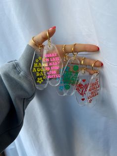 a person holding four key chains in their hand