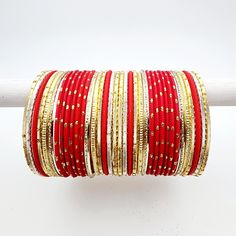 This elegant bangle set is designed in a stunning shade of red with intricate gold accents. The set includes bangles for both arms, offering a harmonious blend of vibrant color and exquisite detailing. Shade Of Red, Team Members, Bangle Set, Shades Of Red, Gold Accents, Bangles, Vibrant Colors, Purple, 10 Things