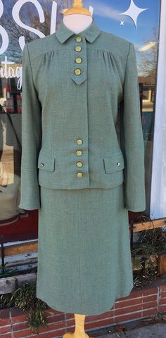 "This 1940's light green skirt set is in incredible condition and would make a great addition to every closet! The jacket is a boxy cut with two small pockets and decorative square buttons. There is no material information available, but my best guess is that the set is made from a thick cotton blend, it feels like a lightweight twill. Both the skirt and jacket are lined in an orange washed silk. The skirt's waist has been altered, it currently measures at 25\", and a metal zipper was added (see photos).  There are no tags on the skirt; the jacket has three tags (please see photos). Please note that the rhinestone detail on the right pocket is missing two stones (see photo).  Features: -Square Buttons -Two Small Jacket Pockets -Rhinestone Detail on Jacket Pockets -Slit in Cuff -Small Shoul Classic Fitted Green Skirt Suit, Classic Green Fitted Skirt Suit, Vintage Skirt Suit With Buttons For Office, Vintage Office Skirt Suit With Buttons, Vintage Skirt Suit With Button Closure For Formal Occasions, Vintage Formal Skirt Suit With Button Closure, Tailored Green Skirt Suit For Office, Classic Green Skirt Suit For Work, Green Tailored Skirt Suit For Office