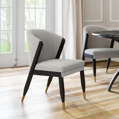 two chairs sitting next to each other on top of a hard wood floor