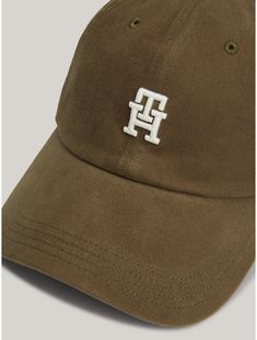 Tommy Hilfiger women's hat. An embroidered TH monogram lends a contemporary edge to this soft textured baseball cap, ideal for bright sunny days (and bad hair days).  Material: 100% Better Cotton Initiative. Solid Color Hat With Embroidered Logo And Curved Visor, Casual Solid Baseball Cap With Embroidered Logo, Classic Spring Hats With Embroidered Logo, Classic Spring Hat With Embroidered Logo, Classic Dad Hat With Embroidered Logo For Spring, Trendy Brown Hat With Embroidered Logo, Trendy Brown Baseball Cap With Curved Visor, Trendy Visor Hat With Embroidered Logo, Casual Beige Baseball Cap With Embroidered Logo