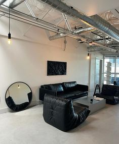 a living room with black leather furniture and mirrors