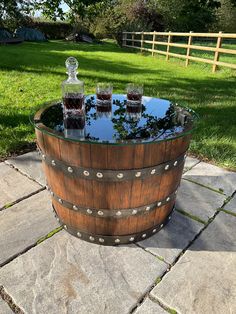 three glasses sitting on top of a wooden barrel