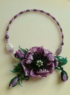 a purple beaded necklace with flowers and beads