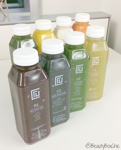 six bottles of juice are lined up on the counter