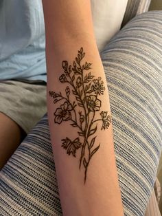 a woman's arm with a flower tattoo on the left side of her arm